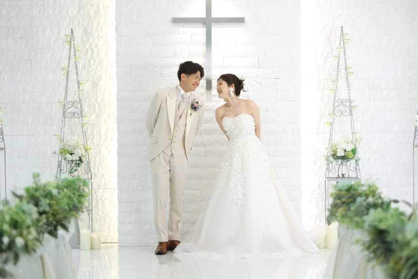 チャペルで向き合う洋装の新郎新婦のフォトウェディング・柔らかな光が包む上品な一枚
