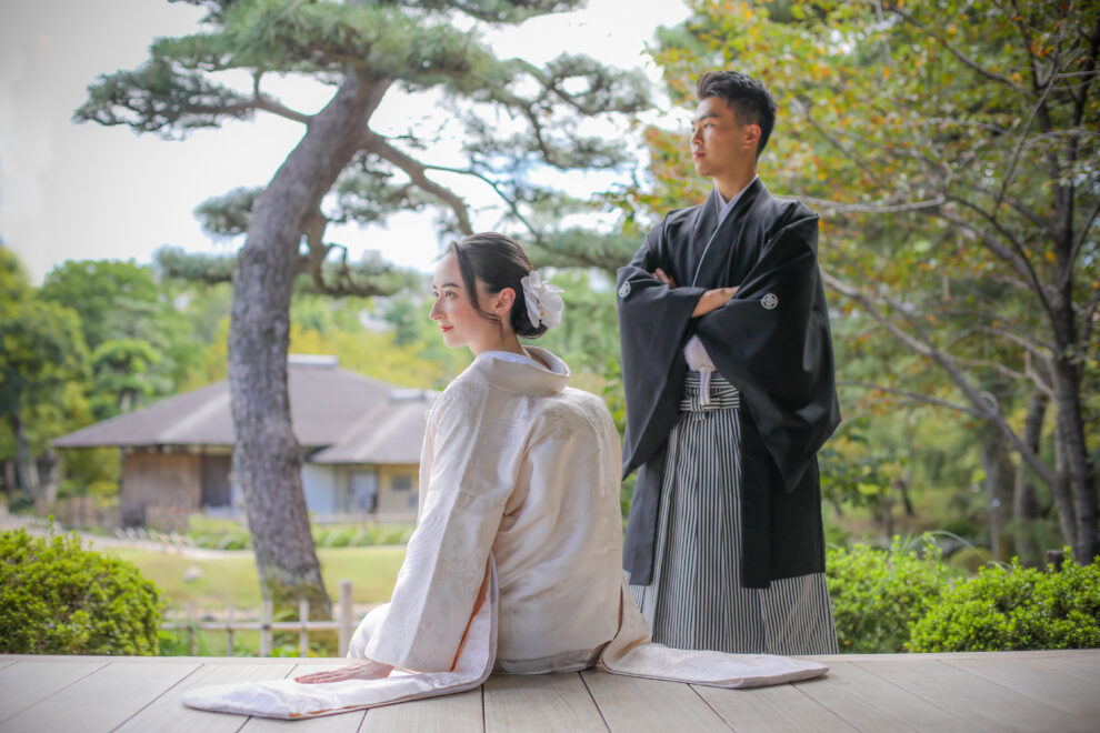 東屋で並ぶ新郎新婦の和装フォト・白無垢と黒紋付が庭園の緑に映える落ち着いたロケーションショット