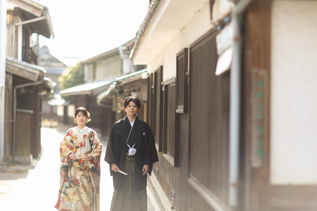 伝統的な町並みを歩く和装の新郎新婦のフォトウェディング・柔らかな光が包む和の風景