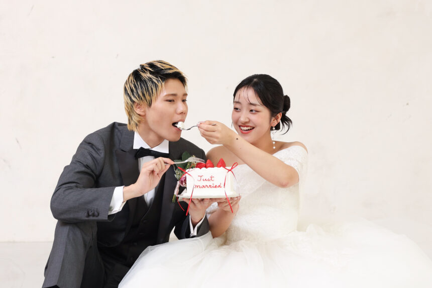 ケーキを食べさせ合う新郎新婦のフォトウェディング・Just marriedのケーキが可愛らしい祝福シーン