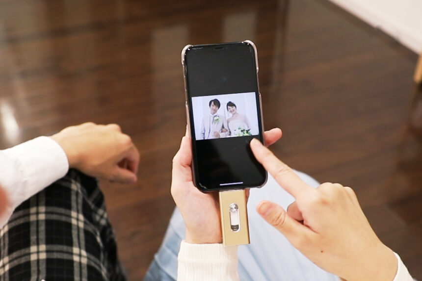 スマートフォンで結婚写真を確認する様子・USBメモリに保存したウェディングフォトを見返す日常の一瞬