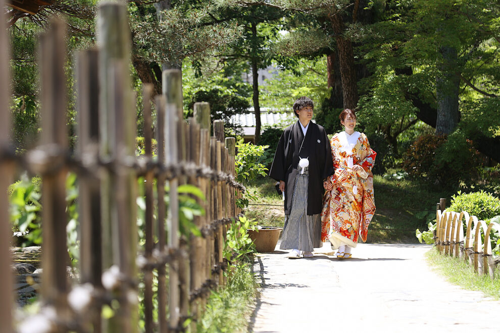 庭園の緑道を歩く和装の新郎新婦の前撮り・広島らしい自然に包まれたロケーションショット